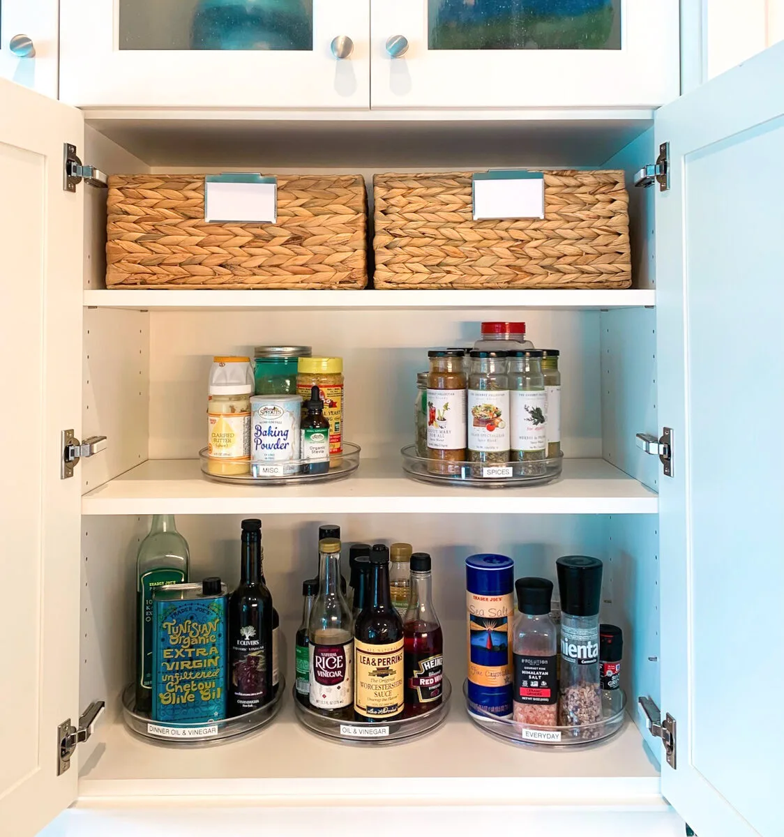 An organized kitchen cabinet with turntables and lazy Susans after a session with Kim